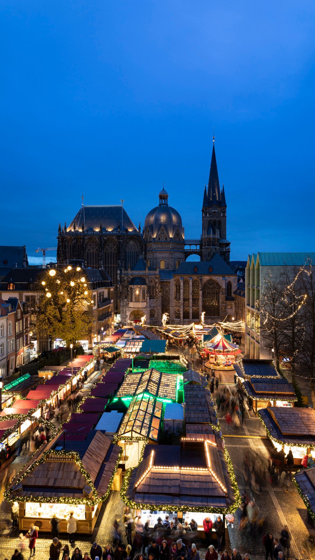 Tourismus NRW e.V., Ralph Sondermann, Zelte auf dem Aachener Weihnachtsmarkt mit Hochhäusern