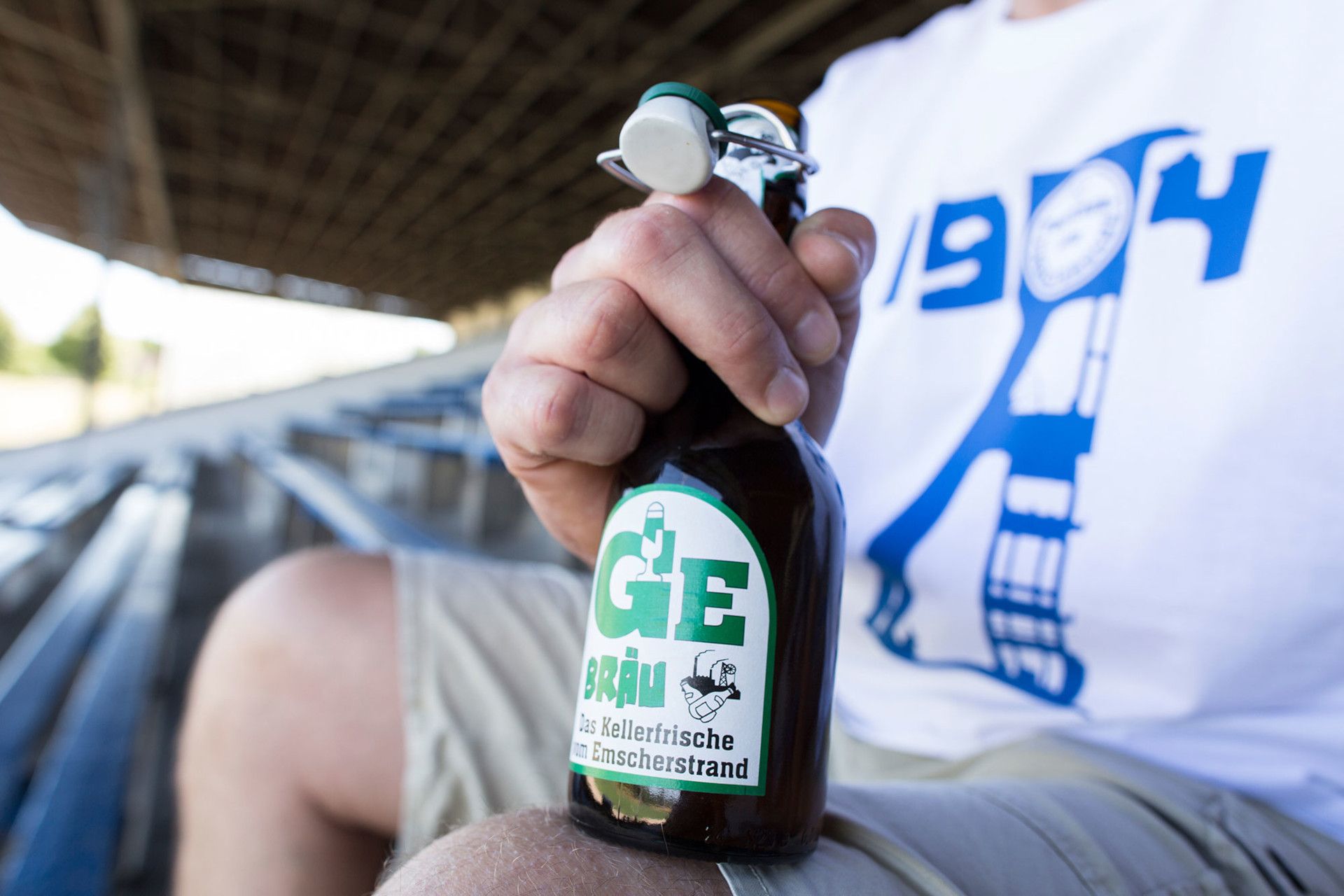 Ralph Sondermann, Tourismus NRW e.V., Gebräu Bierflasche auf Fußballtribüne in Stuttgart