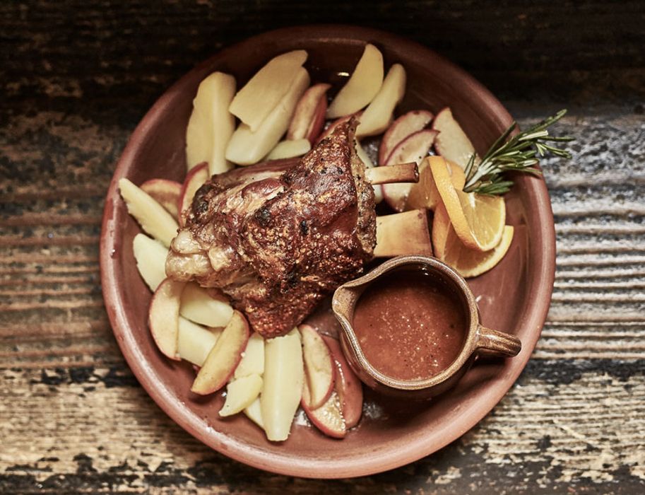 The pork knuckle Herzog is served with caramelized apple slices, field potatoes and Calvados sauce