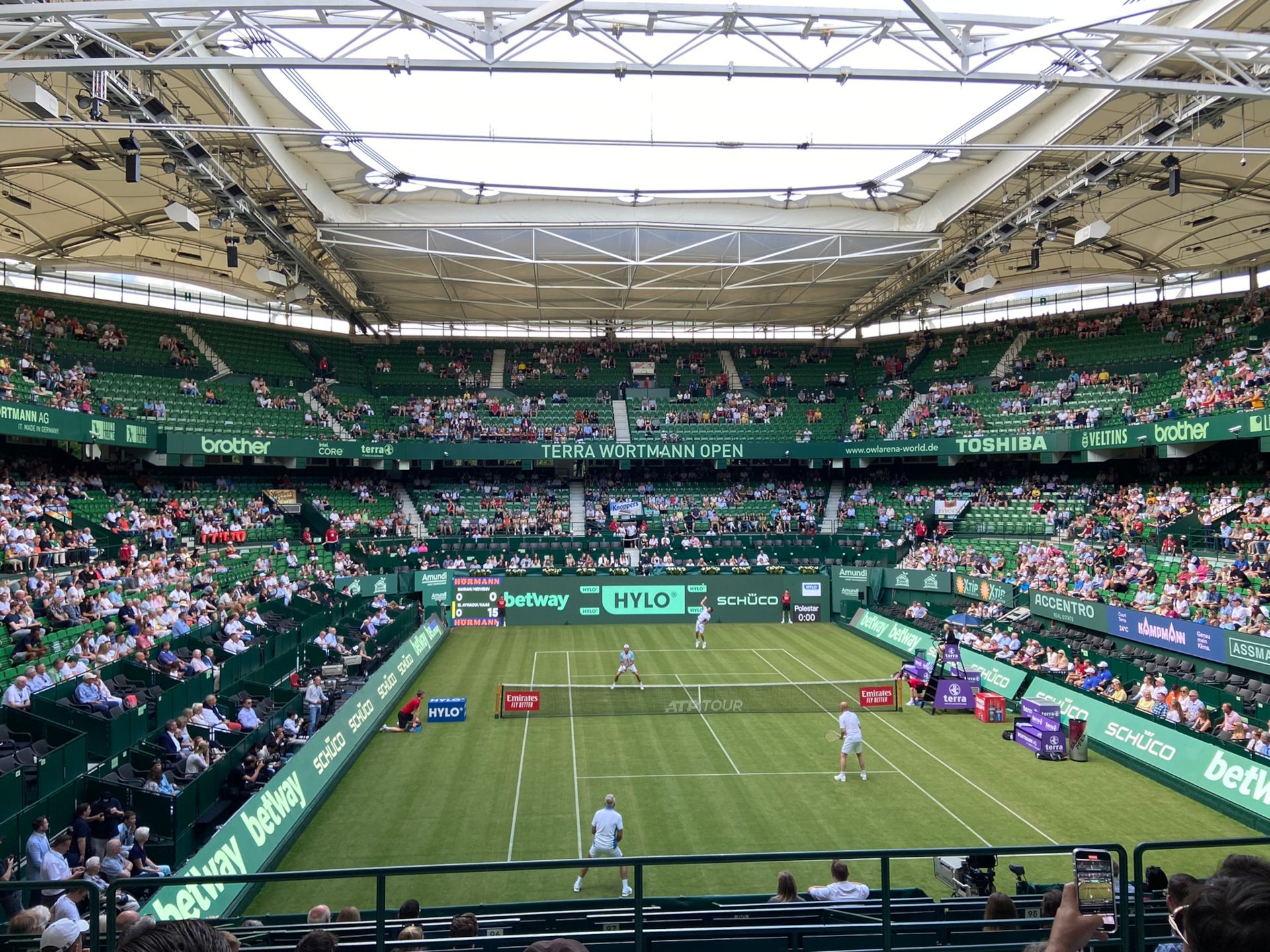 Spectators watch the tennis court with excitement. Stars of the scene compete in individual matches